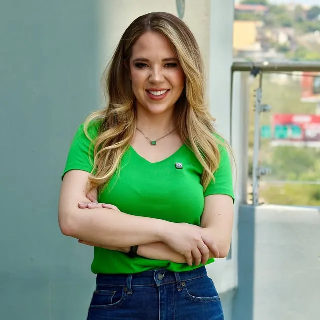 Claudia Chapa con playera verde, sonriendo al aire libre